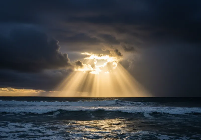 Sunlight breaking through storm clouds over the sea
